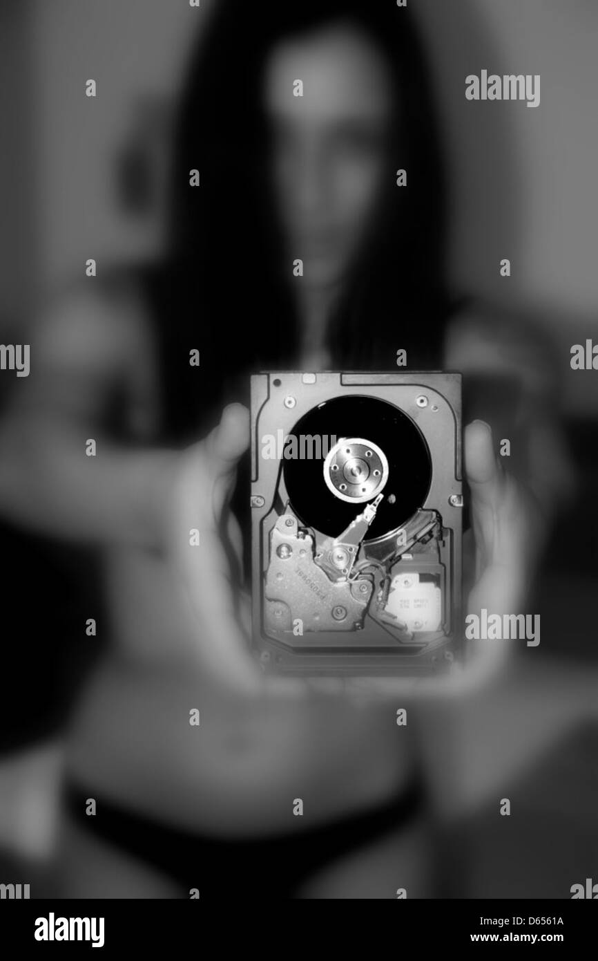 Nahaufnahme des Innenraums einer 15.000 SCSI-Festplatte. Die Hände einer Frau werden beobachtet, wie sie die empfindlichen Komponenten des Antriebs sorgfältig handhaben und die komplizierte mechanische Struktur deutlich machen. Stockfoto