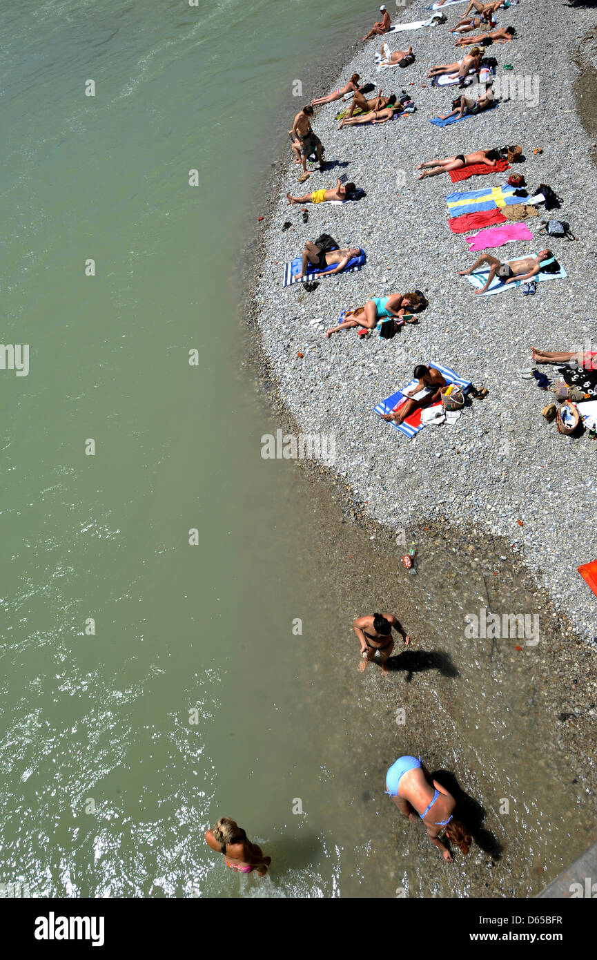 Die Menschen genießen das Wetter am Fluss Eisbach im englischen Garten in München, Deutschland, 16. Juni 2012 liegt. Endlich ist der Sommer zurückgekehrt: Temperaturen von bis zu 30 Grad Celsius machten Leute verbringen ihre Zeit in Freibäder, Biergärten und öffentlichen Cafés. Foto: FRANK LEONHARDT Stockfoto