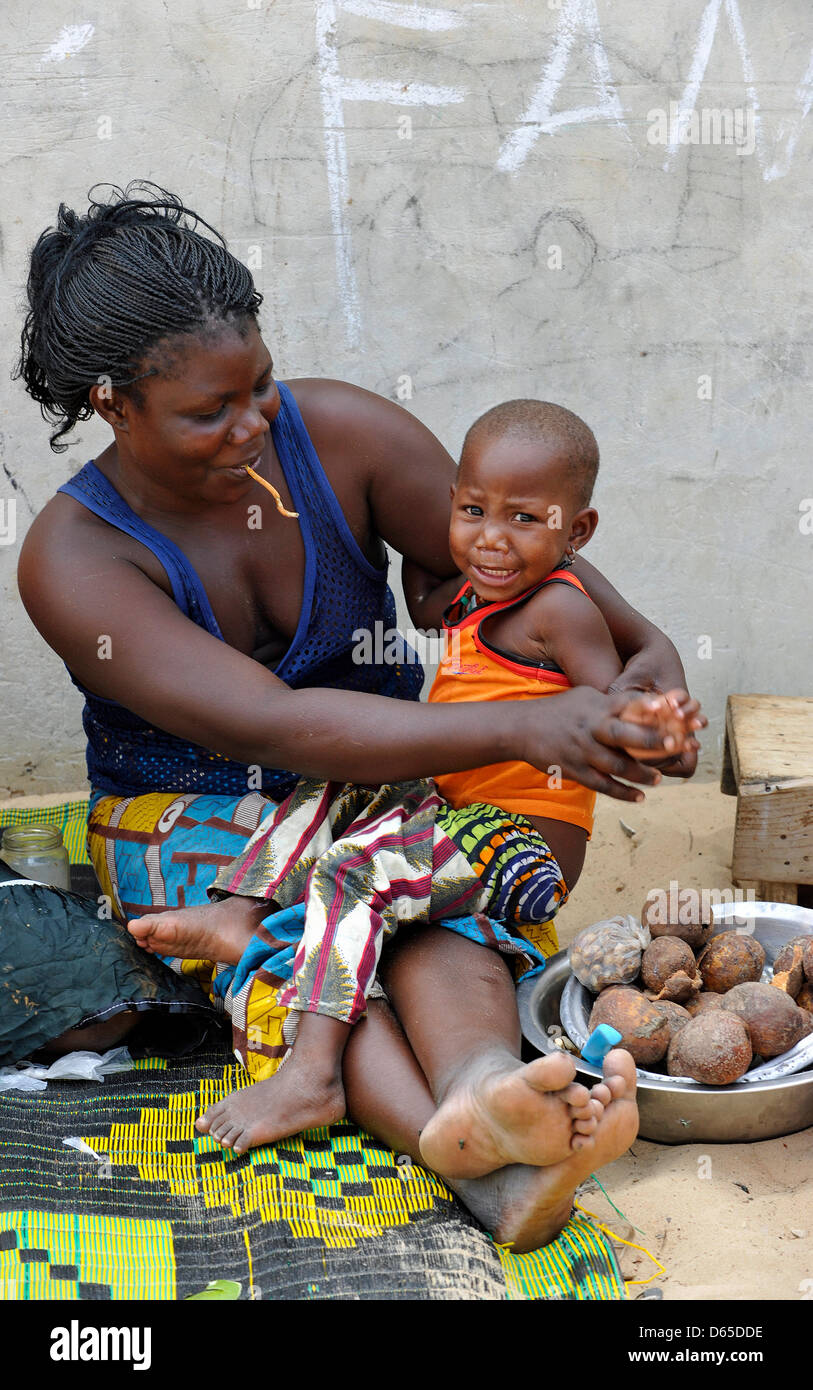 Datei - datiert eine Datei Foto 29. Juni 2011 zeigt eine Frau und ihr Kind sitzt auf einer Straße in einem Vorort von Dakar während eines Besuchs der deutsche Nachrichtensprecherin Gundula Gause in Senegal. Gause besuchte das Land um sich über Projekte der päpstlichen Mission Gesellschaft Missio. Foto: Ursula Düren Stockfoto