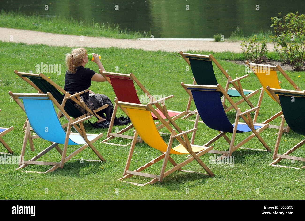 Eine Frau sitzt in einem Park das von Hermann Graf von Pueckler-Muskau in Bad Muskau, Deutschland, 11. Mai 2012 entworfen wurde. 300.000 Besucher kommen jährlich in den Park an der deutsch-polnischen Grenze. Foto: Matthias Hiekel Stockfoto