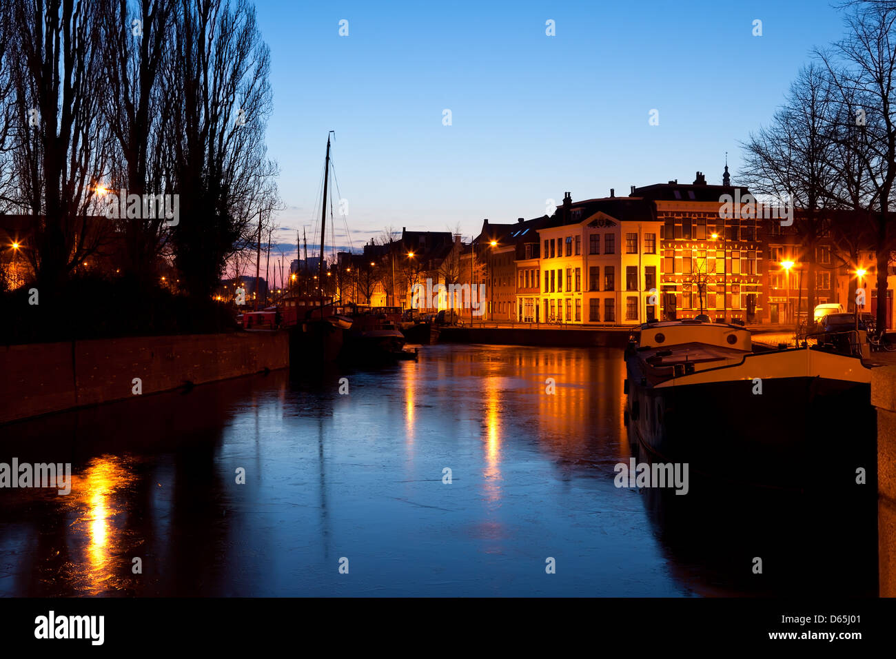 Schiff und Boote auf zugefrorenen Kanal in der Nacht, Holland Stockfoto