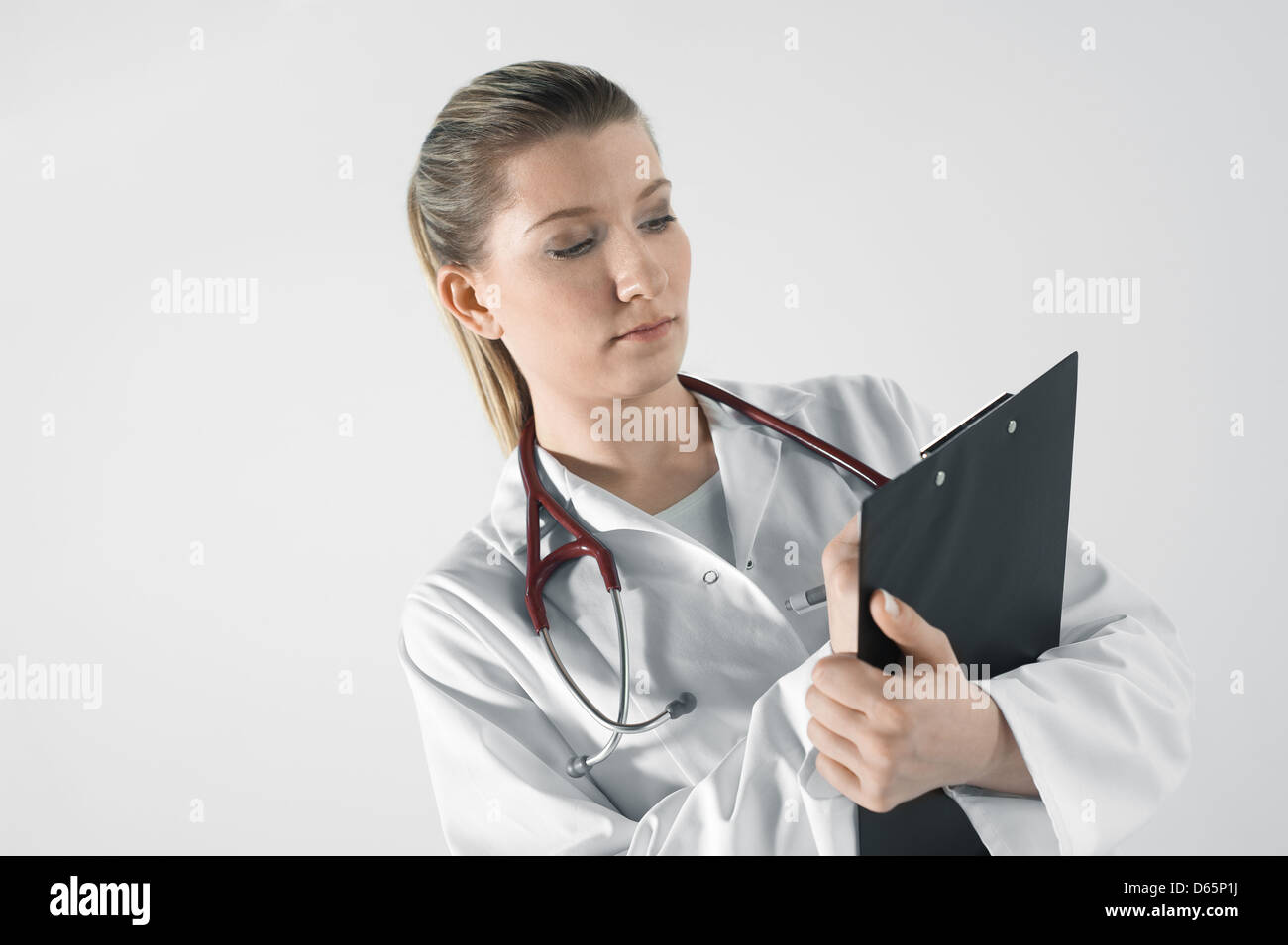Junge Frau Doktor mit Stethoskop und Notepad Stockfoto