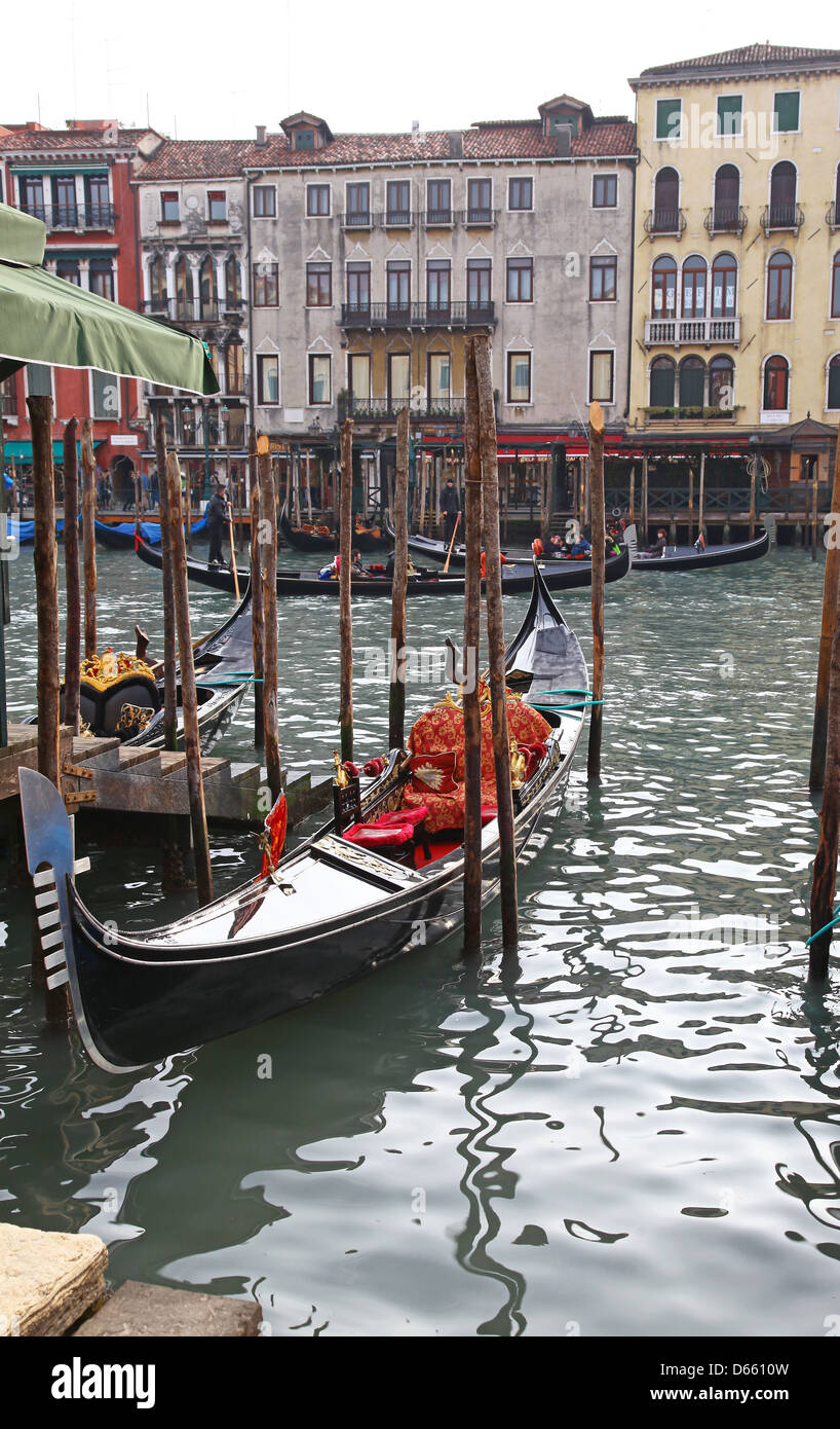 Gondeln, einem historischen klassischen touristischen Attraktion bunte Altbauten und hölzernen Liegeplatz Pfosten oder Stangen Venedig Italien Stockfoto