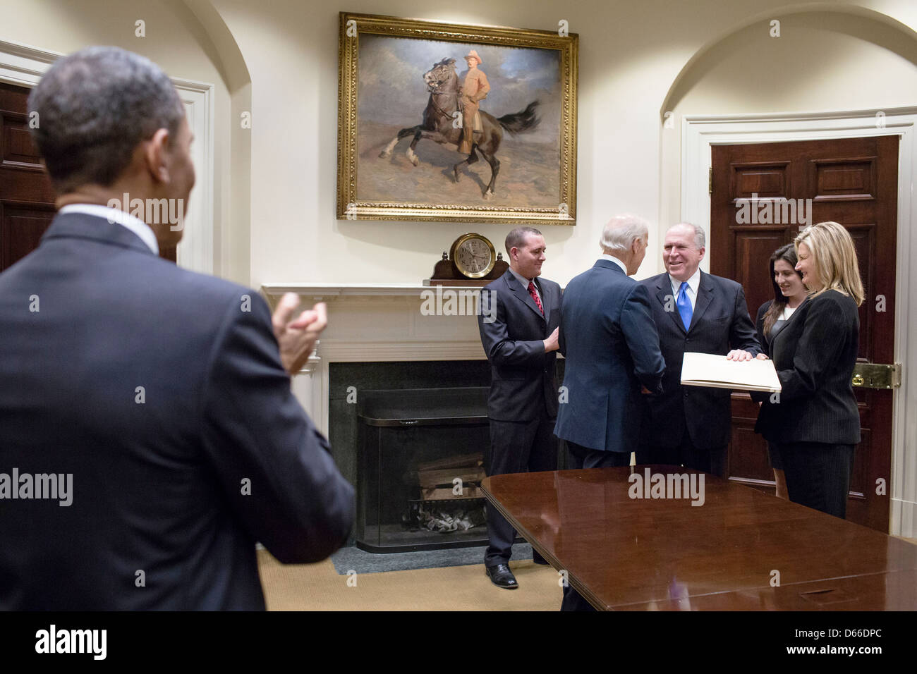 US-Präsident Barack Obama begrüßt als Vize-Präsident Joe Biden schüttelt Hände mit CIA-Direktor John Brennan nach seiner Vereidigung im Roosevelt Room des weißen Hauses 8. März 2013 in Washington, DC. Brennan wurde als neuer Direktor der CIA vereidigt. Stockfoto