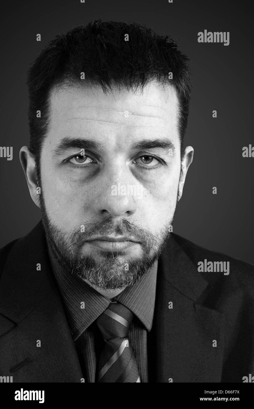 Schwarz-weiß-Porträt von traurig oder wütend Mann im Anzug Stockfoto