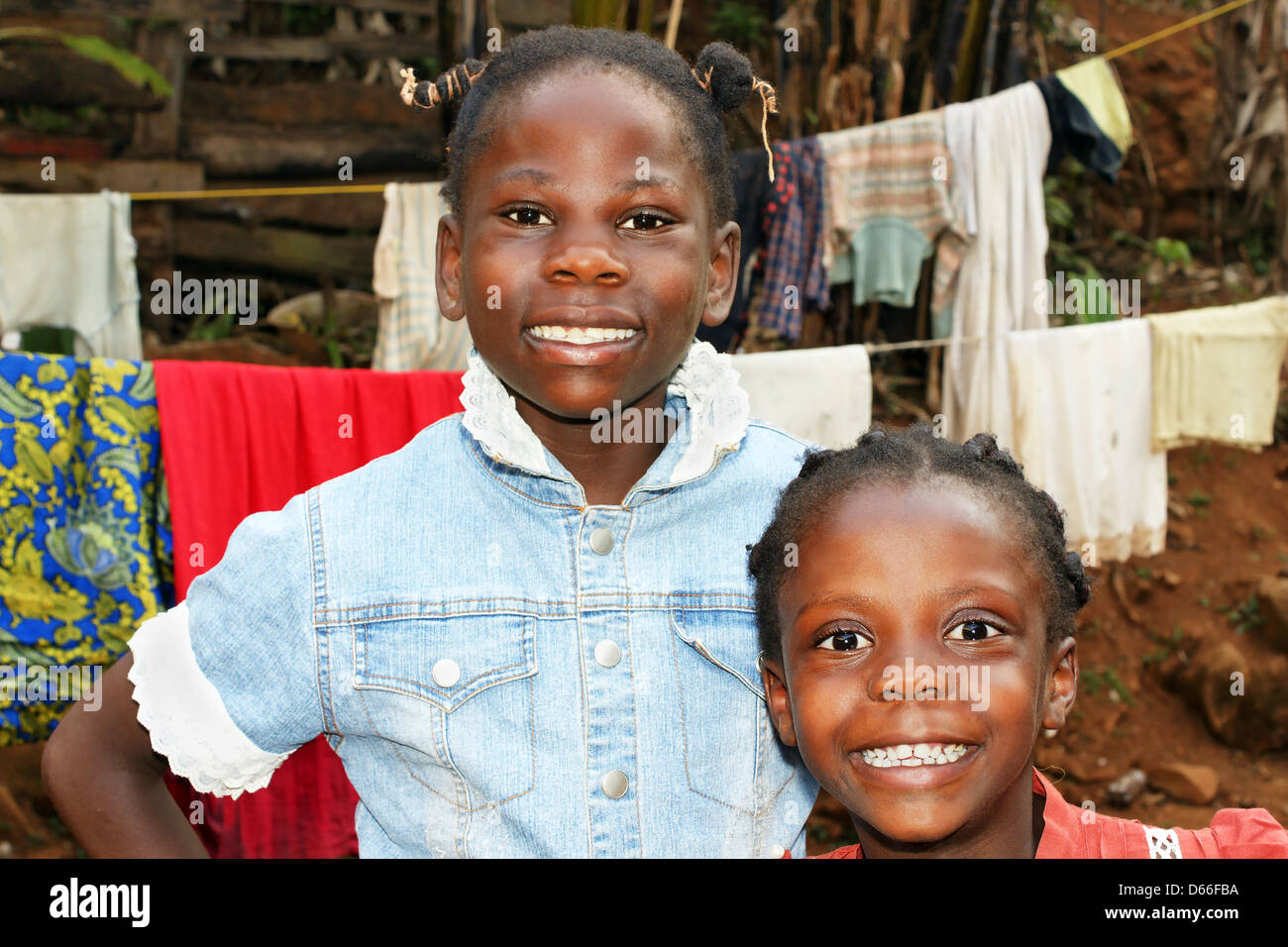 Zwei glückliche Afrikanische schwarze Mädchen, Schwestern, zu Hause mit  Wäscheleine hinter ihnen Stockfotografie - Alamy
