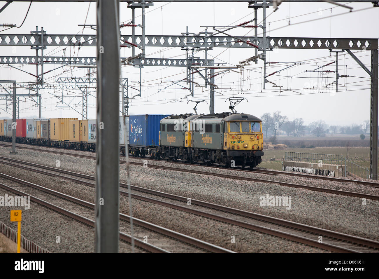 Container Fracht Reisen entlang der West Coast Mainline Railway durch die Midlands. Intermodaler Verkehr genannt. Stockfoto