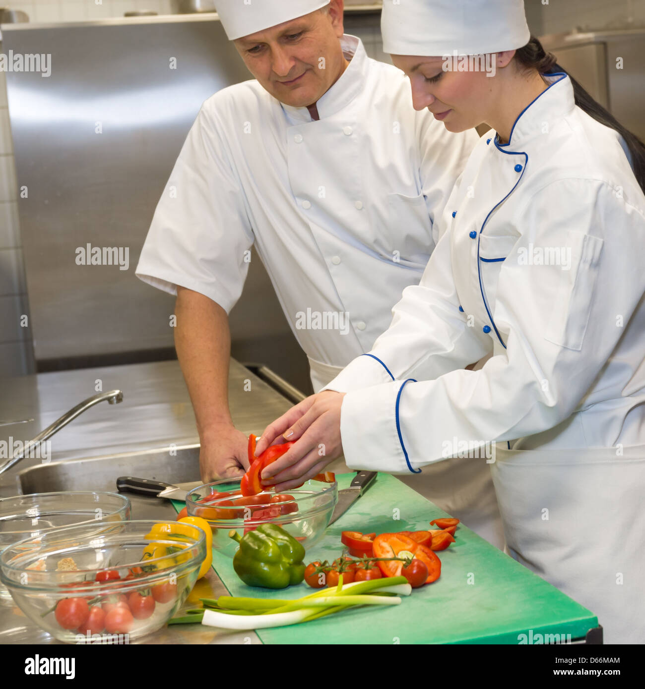 Weibliche und männliche Köche bereitet Salat in der Küche des Restaurants Stockfoto