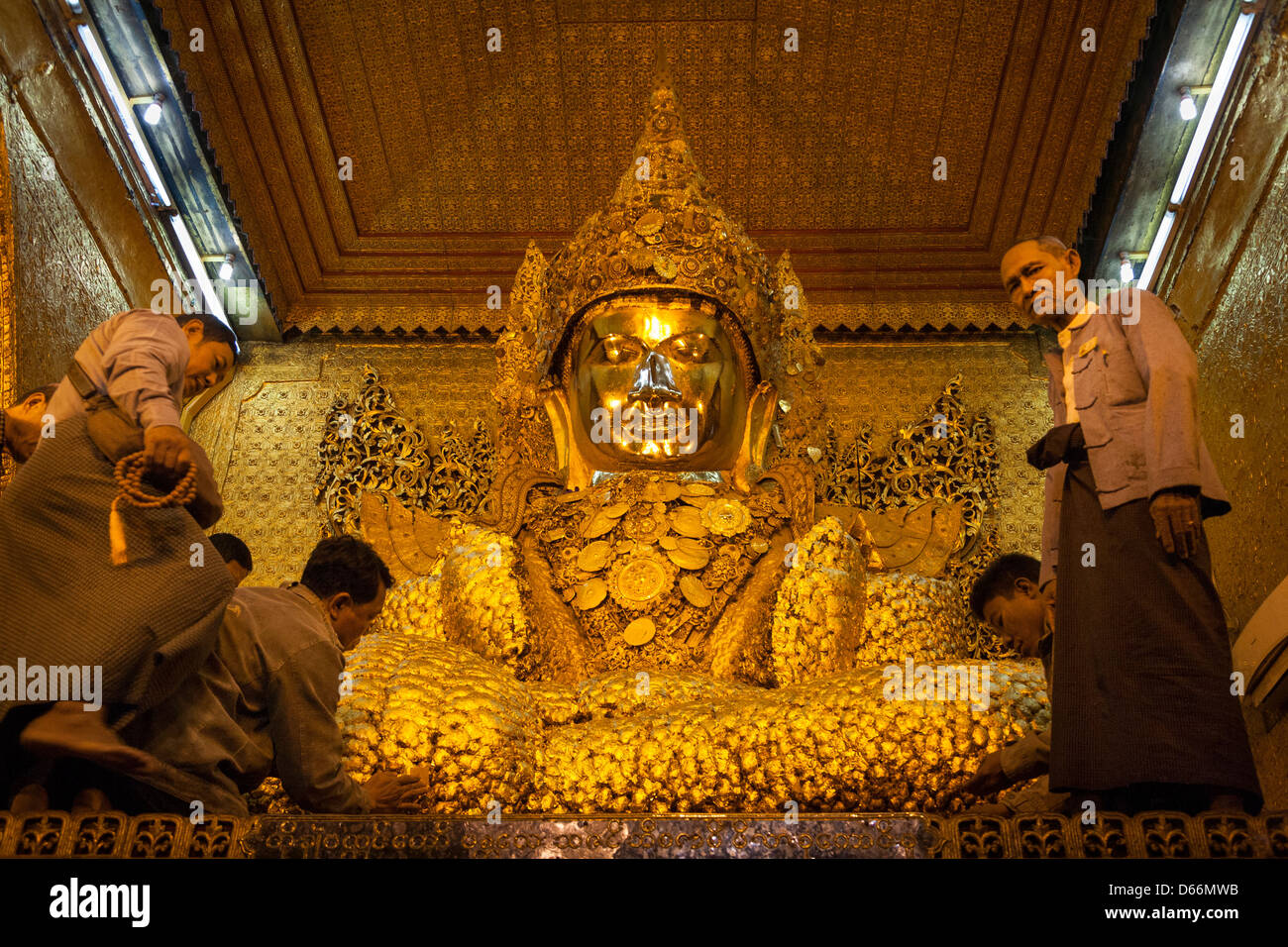 Gläubige, die Anwendung von Blattgold auf Mahamuni Buddha, Mahamuni Pagode, Mandalay, Myanmar (Burma) Stockfoto