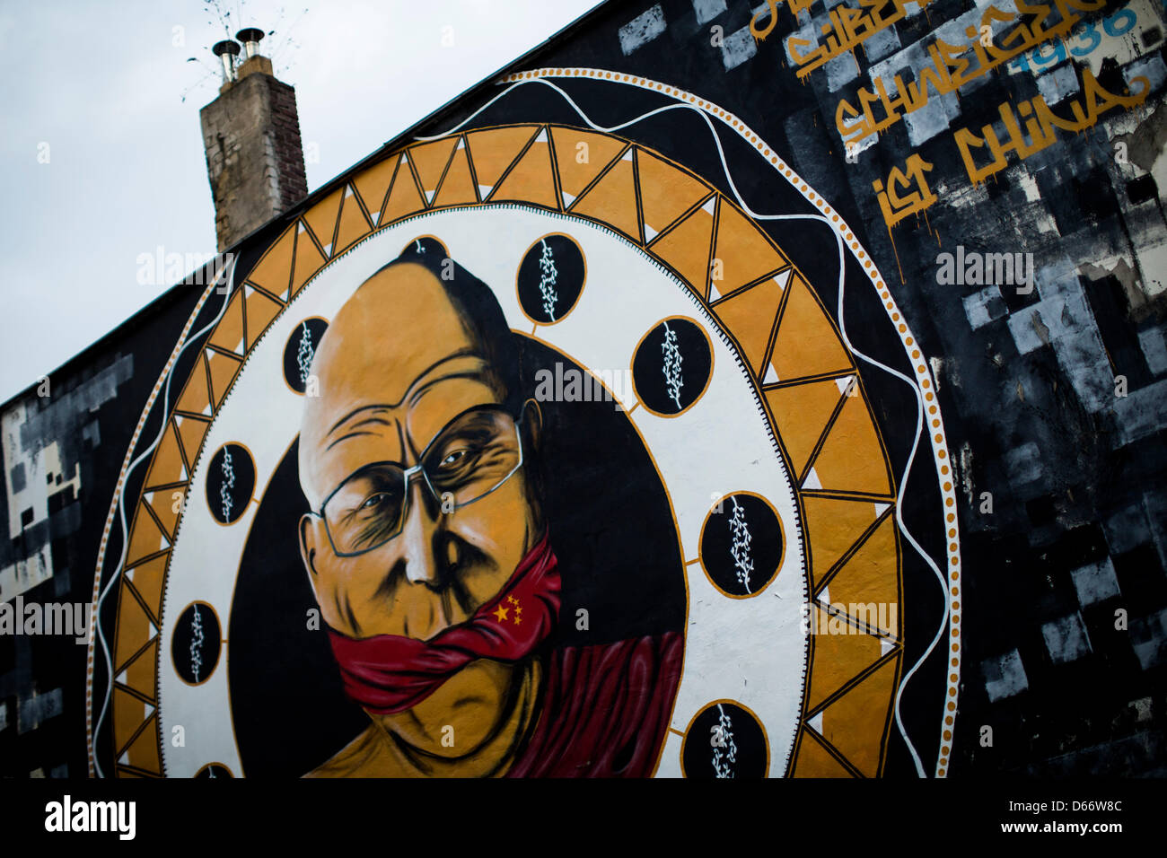 Eine Wandmalerei zeigt den Führer des tibetischen Buddhismus, Dalai Lama, geknebelt durch eine chinesische Flagge in Köln, 13. April 2013. Die elf Meter hohe Malerei unter dem Motto "reden ist Silber, Schweigen ist China" von Streetart-Künstler B. Shantly wurde von Amnesty International in Köln beauftragt. Foto: Rolf Vennenbernd Stockfoto