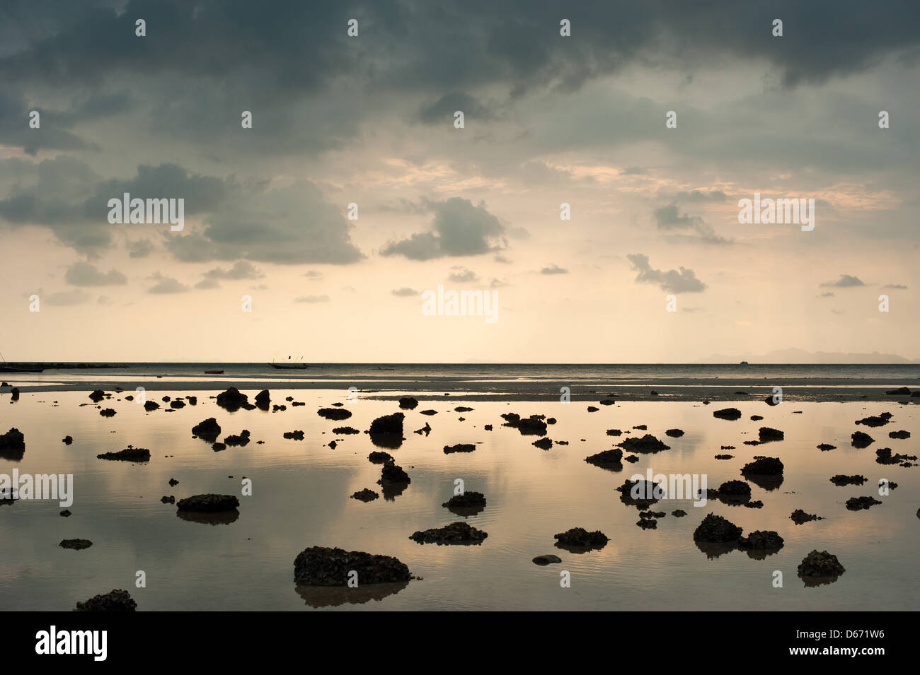 Sonnenuntergang am tropischen Strand. Cay und Felsen an der Küste des Ozeans unter Abendsonne bei Flut. Thailand-Landschaft Stockfoto