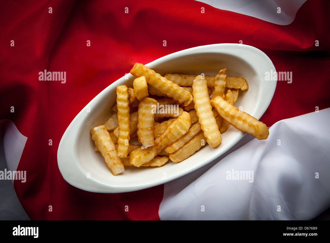 Ein Teller mit Crinkle-Schnitt-Chips auf einem drapierten englische Flagge Stockfoto