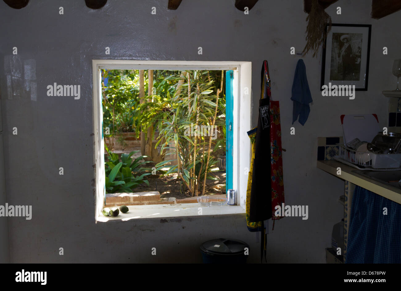 Blick aus dem Küchenfenster in einem mexikanischen Haus in Todos Santos, Mexiko mit Blick auf eine exotische, tropische Garten außerhalb. Stockfoto