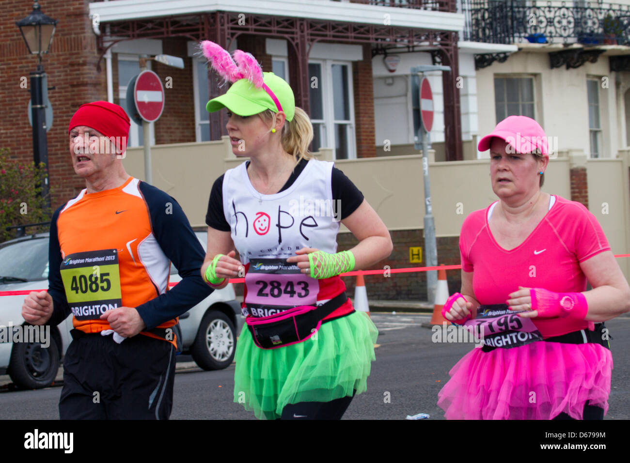 Glaube, Hoffnung und Liebe: Brighton Marathon-Läufer verhandeln Marine Parade. Tausende Menschen säumten die 26-Meile Strecke anfeuern der Läufer, viele von ihnen Geld für wohltätige Zwecke zu sammeln Stockfoto