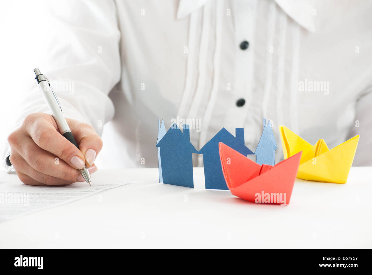Hand ausfüllen des Formulars mit Papier Häuser und Schiffe im Vordergrund. Stockfoto