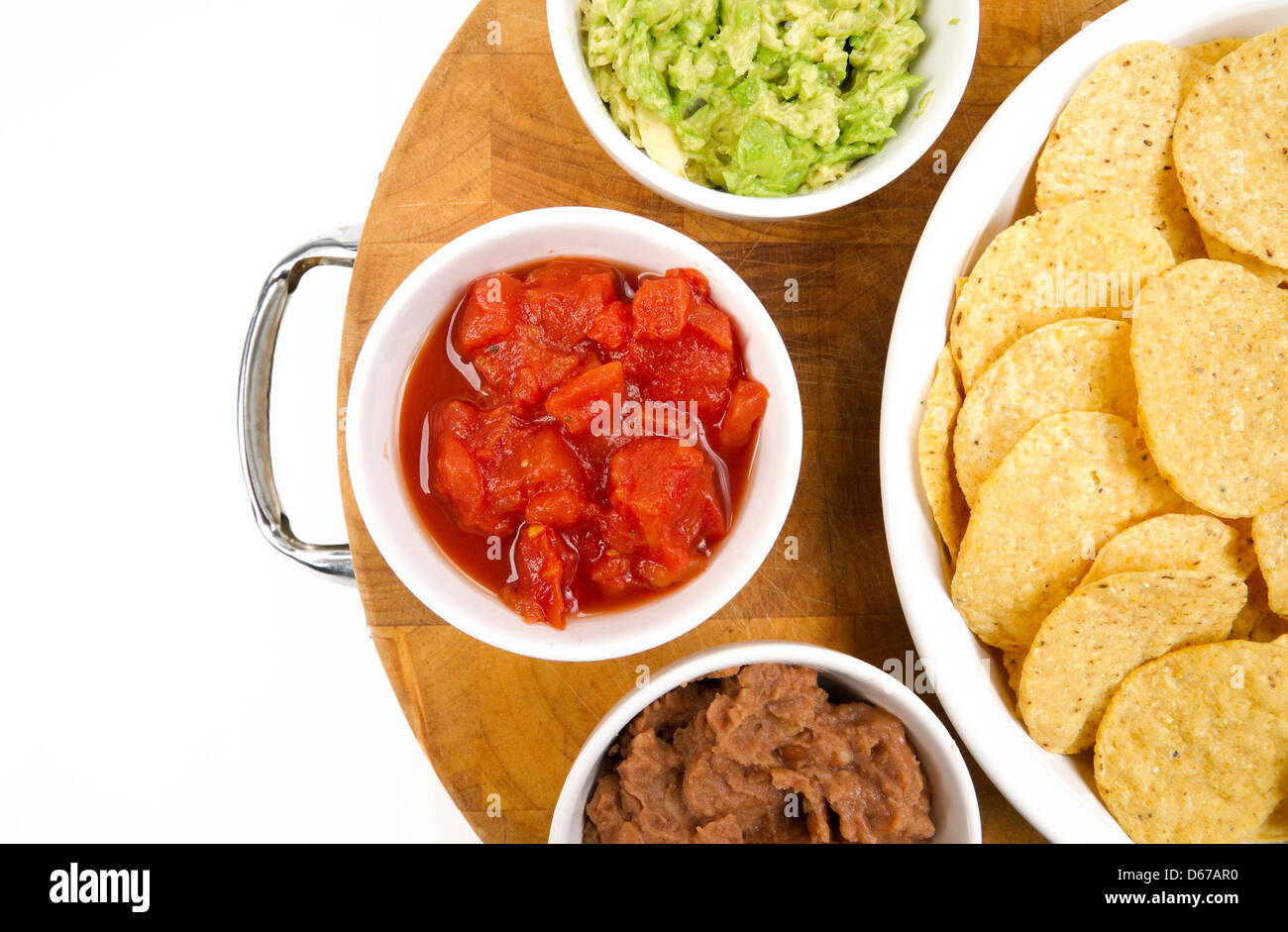 Essen Vorspeisen Chips und Salsa Bohnenmus Guacamole auf Holz Schneidebrett Stockfoto