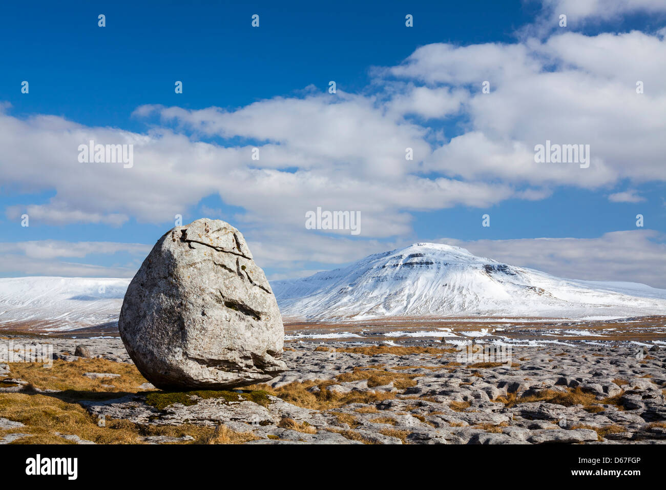 Kalkstein Findling auf Twisleton Narben mit Schnee bedeckt Ingleborough im Hintergrund. North Yorkshire. Stockfoto