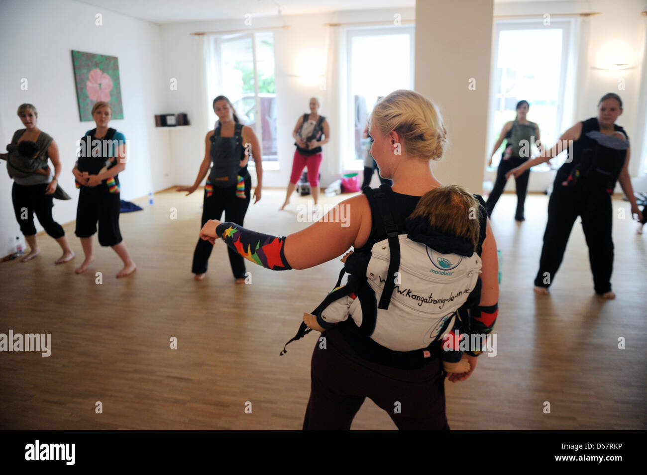 Mütter mit ihren Babys sind mit Trainer Simone Koch (vorne) beim Kanga-Training  in Berlin, Deutschland, 22. Juni 2012 abgebildet. Kanga-Training ist ein  neues Training, so dass Mütter mit ihren neugeborenen Babys in