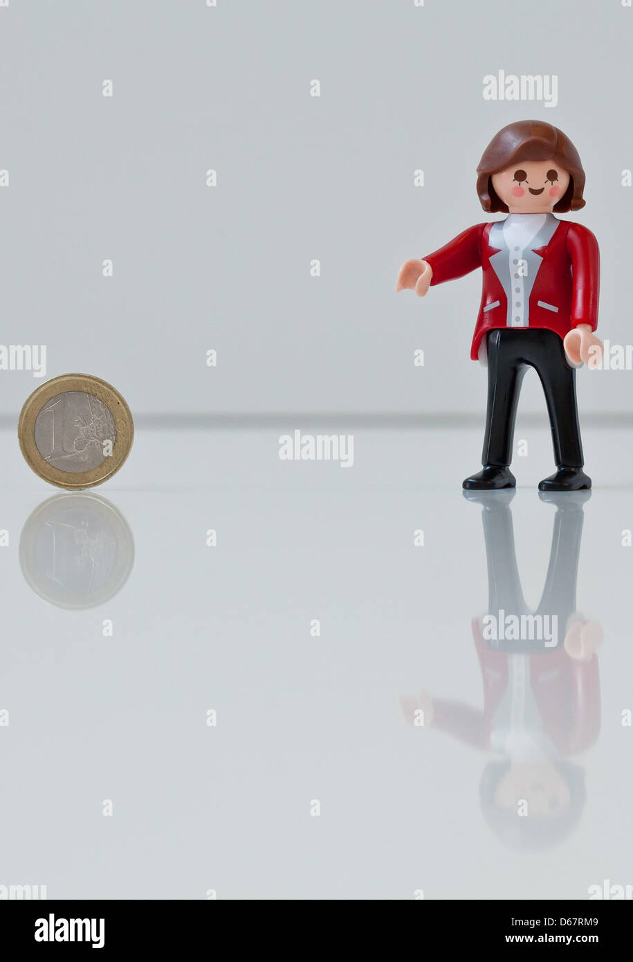 Eine Abbildung zeigt Bundeskanzlerin Angela Merkel als Playmobil-Figur hält eine Euro-Münze auf der Spielzeughersteller Playmobil in Zirndorf, Deutschland, 28. Juni 2012. Die Figur war ein Geschenk für die deutsche Bundeskanzlerin und werden nicht verkauft. Heute treffen sich die europäischen Staats-und Regierungschefs auf dem zweitägigen EU Gipfel in Brüssel. Foto: Daniel Karmann Stockfoto