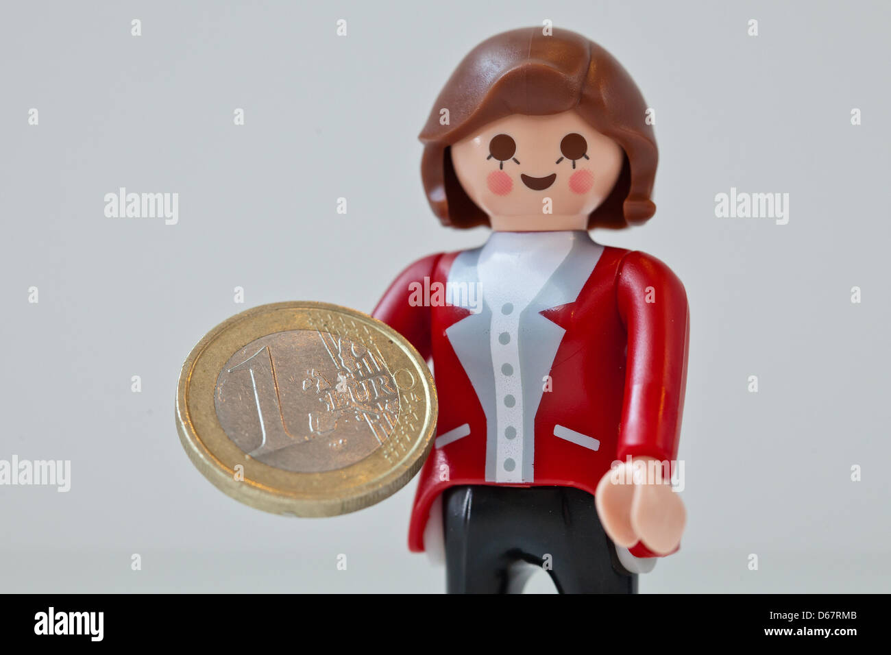 Eine Abbildung zeigt Bundeskanzlerin Angela Merkel als Playmobil-Figur hält eine Euro-Münze auf der Spielzeughersteller Playmobil in Zirndorf, Deutschland, 28. Juni 2012. Die Figur war ein Geschenk für die deutsche Bundeskanzlerin und werden nicht verkauft. Heute treffen sich die europäischen Staats-und Regierungschefs auf dem zweitägigen EU Gipfel in Brüssel. Foto: Daniel Karmann Stockfoto