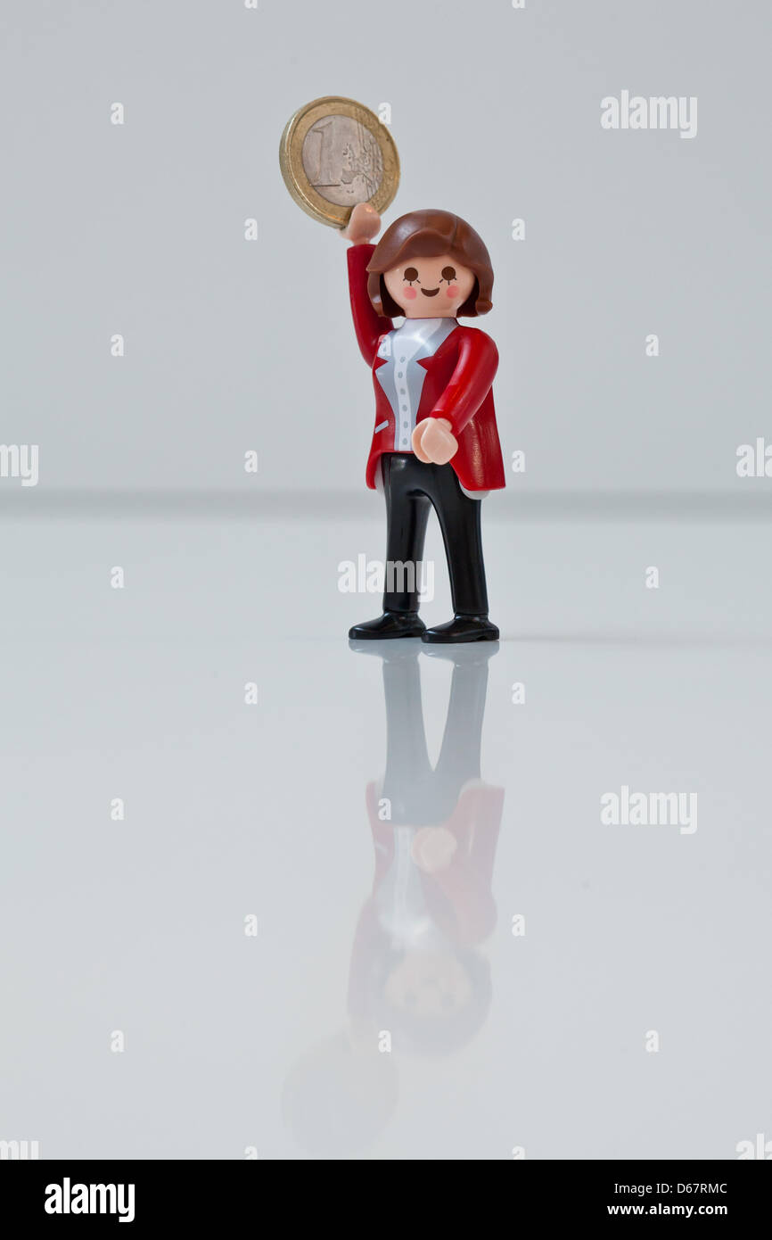 Eine Abbildung zeigt Bundeskanzlerin Angela Merkel als Playmobil-Figur hält eine Euro-Münze auf der Spielzeughersteller Playmobil in Zirndorf, Deutschland, 28. Juni 2012. Die Figur war ein Geschenk für die deutsche Bundeskanzlerin und werden nicht verkauft. Heute treffen sich die europäischen Staats-und Regierungschefs auf dem zweitägigen EU Gipfel in Brüssel. Foto: Daniel Karmann Stockfoto