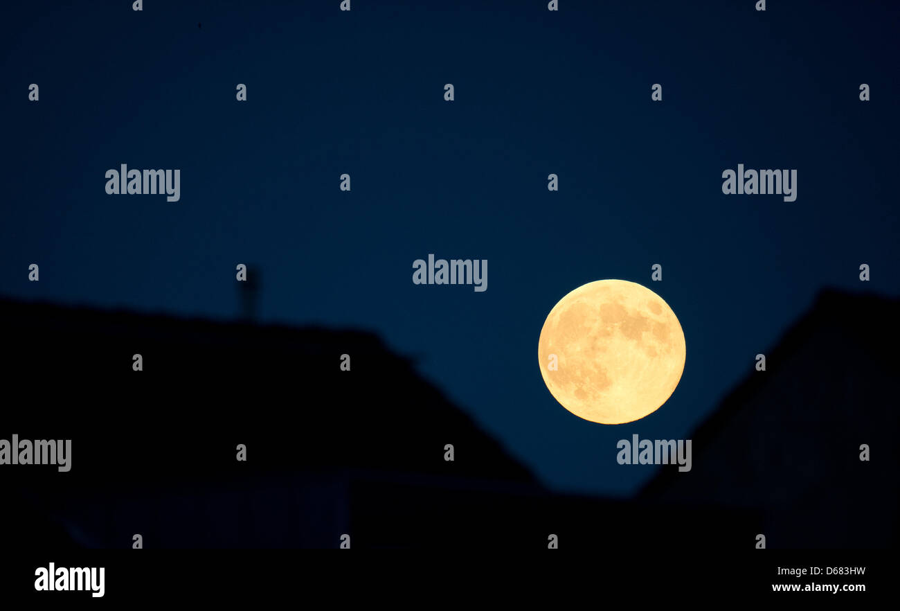 Ein Vollmond steigt über einige Häuser in Hannover, 3. Juli 2012. Meteorologen prognostizieren wechselnden Wetterbedingungen für die nächsten paar Tage. Foto: Jochen Luebke Stockfoto