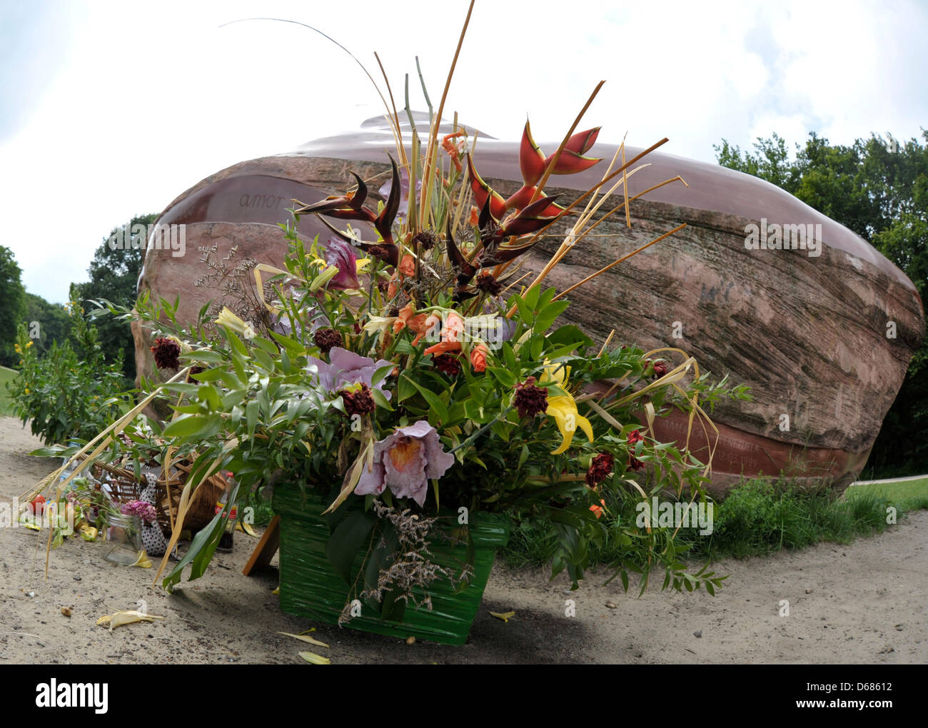 Opfergaben sind vor dem sogenannten "Kueka" Stein im Tiergarten Park in Berlin, Deutschland, 5. Juli 2012 gelegt worden. Die Stein misst 5 m Länge, wiegt rund 35 t und ist seit 1999 Teil eines Kunstprojekts. Die Republik Venezuela Insits die Stein zurückgegeben werden, wie der Stamm der Pemon Indiana im Süden von Venezuela er heilig erachtet. Foto: MARKUS Stockfoto