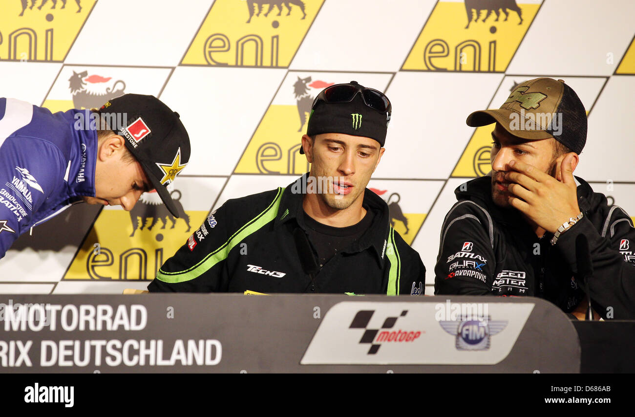 Spanische MotoGP Fahrer Jorge Lorenzo (L-R) von Team Yamaha Factory Racing setzt entfernt, seine Krücken neben italienischen Fahrer Andrea Dovizioso von Monster Yamaha Tech 3 Team und italienischen Mattia Pasini von Team Speed Master vor einer Pressekonferenz beim Rennen Sachsenring in Hohenstein-Ernstthal, Deutschland, 5. Juli 2012 verfolgen. Den deutschen Grand Prix findet am den 85. Jahrestag der Stockfoto