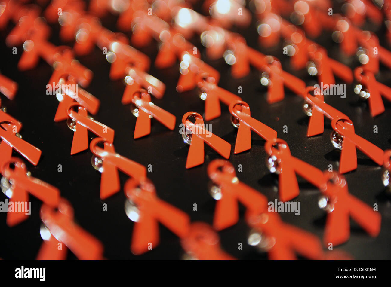 (DATEI - ILLUSTRATION) Archiv zur Veranschaulichung vom 6. November 2010 zeigt AIDS Ribbon Pins auf einem Tisch in Berlin, Deutschland. Zum ersten Mal wurde ein Medikament zugelassen, um vor einer HIV-Infektion zu verhindern. Foto: Jens Kalaene Stockfoto