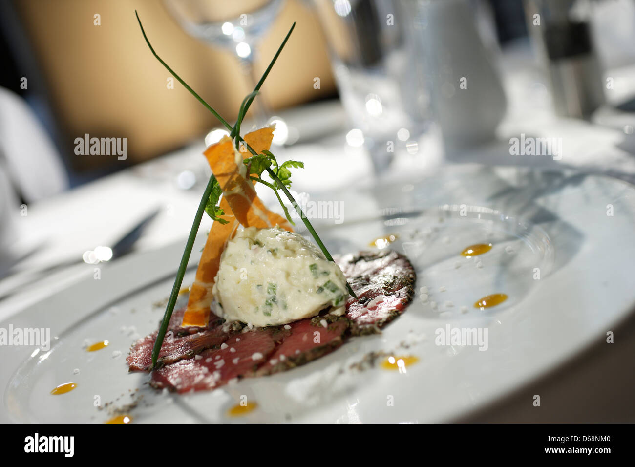 Rindercarpaccio mit Meerrettich-Soße &amp; Orange-Coulis auf einem weißen ...