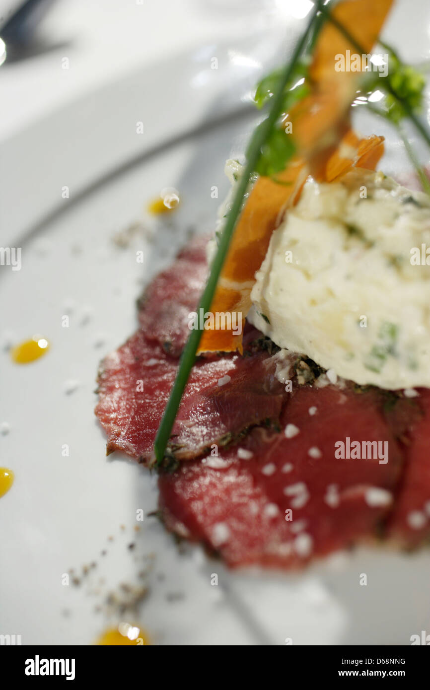 Rindercarpaccio mit Meerrettich-Soße &amp; Orange-Coulis auf einem weißen ...