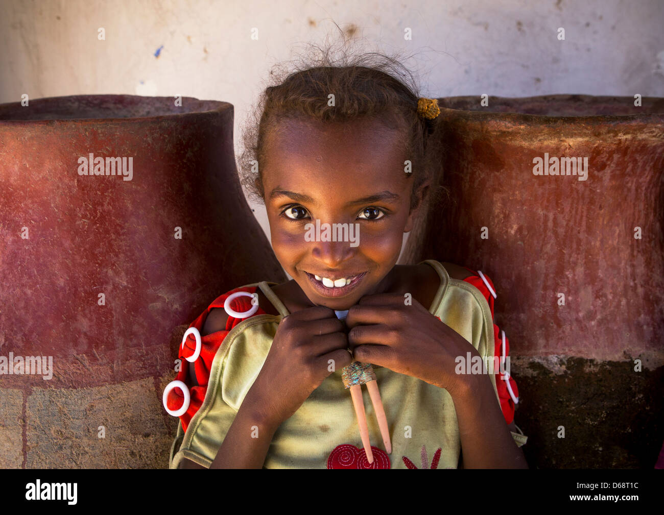 Lächelnde sudanesischen Mädchens vor Wasserkrüge, Gunfal, Sudan Stockfoto