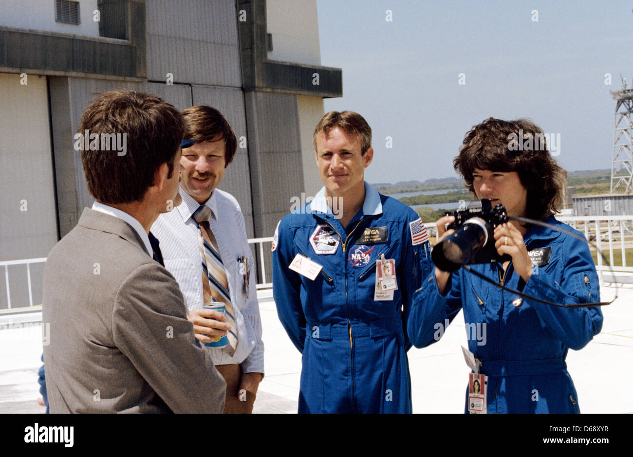 Astronaut Sally K. Ride, Missionsspezialisten für STS-7, geplant für Juni 1983 zeichnet einige Pre-Launch-Aktivitäten für STS-6 auf 35 mm-Film auf dem Kennedy Space Center (KSC), USA, 4. April 1983. Astronaut William B. Lenoir, STS-5 Missionsspezialisten, ist auf der linken Seite. Andere im Bild sind Richard W. Nygren (Mitte), Leiter der Abschnitt Fahrzeug Integration der Operationsabteilung Stockfoto