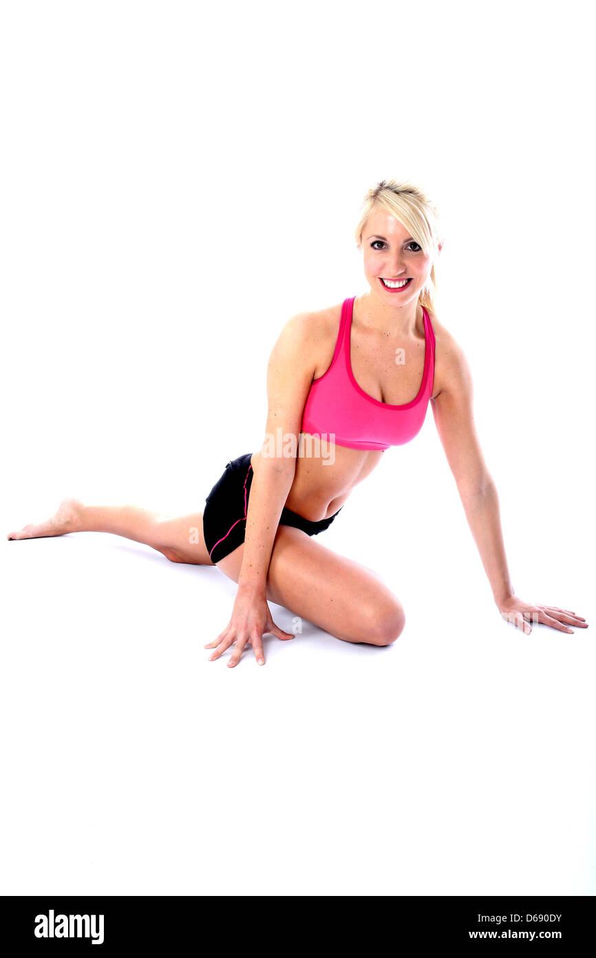 Positive Gesunde junge blonde Frau, Tragen, rosa Top, schwarze Shorts, Fitness Bodenübungen, isoliert weißer Hintergrund, Freistellungspfad Stockfoto