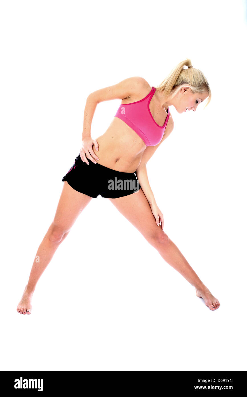 Positive Gesunde junge blonde Frau, Tragen, rosa Top, schwarze Shorts, Fitness Bodenübungen, isoliert weißer Hintergrund, Freistellungspfad Stockfoto