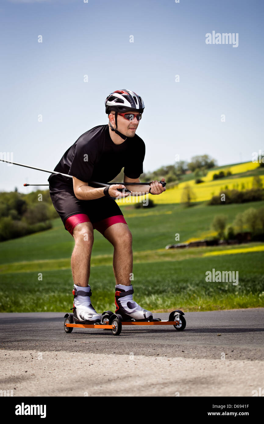 Ein junger Mann-Langlauf mit Roller ski Stockfoto