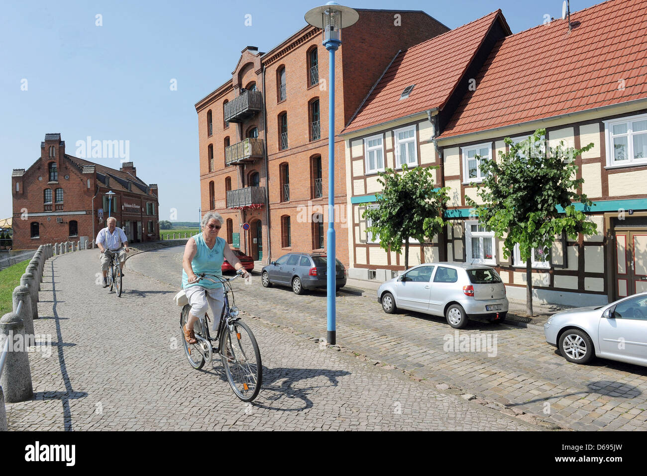 Radfahrer fahren entlang der sanierten Hafenstrasse (Harbour Road) in Wittenberge, Deutschland, 26. Juli 2012. Foto: Bernd Settnik Stockfoto