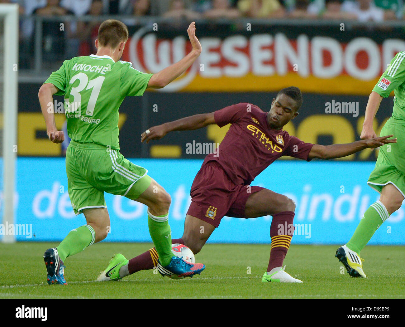 Wolfsburgs Robin Knoche (L) wetteifert um den Ball mit Manchesters Abdul Razak bei einem Testspiel zwischen VfL Wolfsburg und Manchester City in der Volkswagen Arena in Wolfsburg, Deutschland, 4. August 2012. Foto: Dominique Leppin Stockfoto