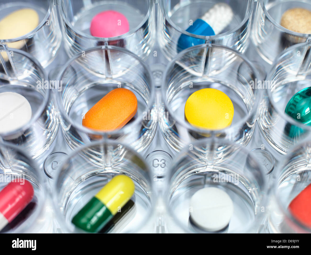 Eine Vielzahl von Medikamenten, die sitzen in einem Multi gut Probenteller Illustrating klinischen Medikamententest Stockfoto