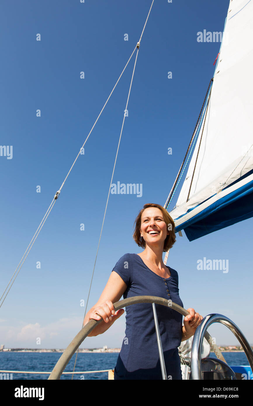 Lächelnde Frau fahren Boot Stockfoto