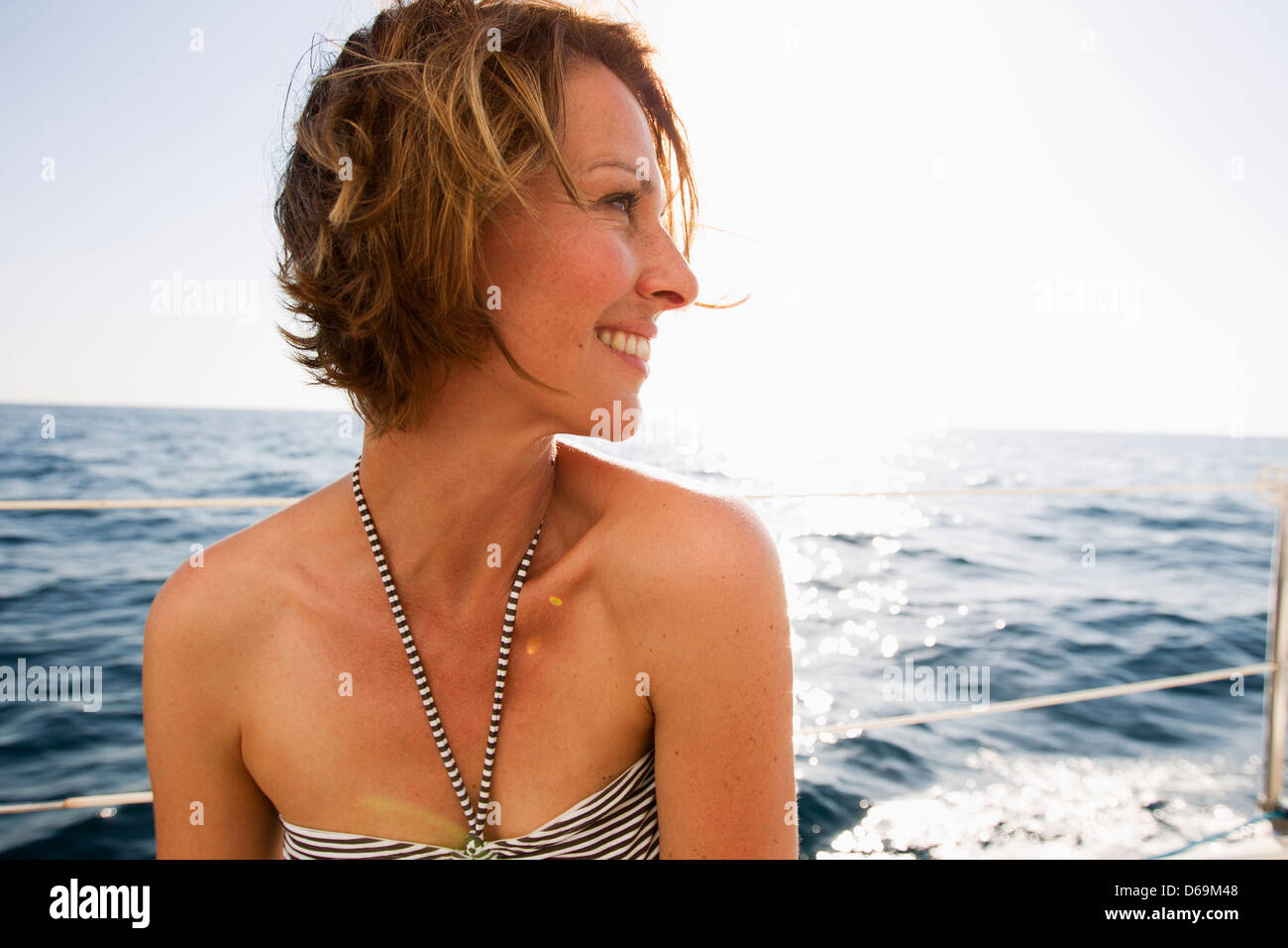Lächelnde Frau im Bikini am Boot Stockfoto
