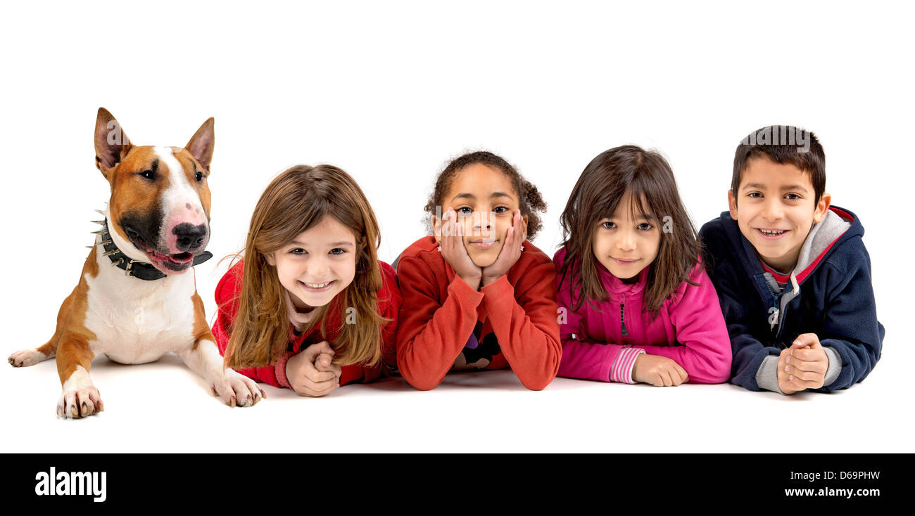 Gruppe von Kindern posiert mit einem Hund isoliert in weiß Stockfoto