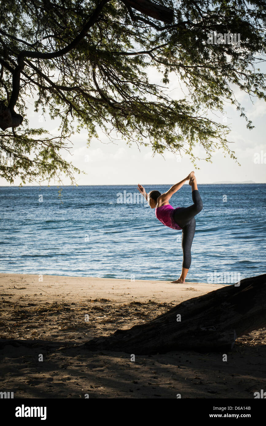 Frau praktizieren Yoga am Strand Stockfoto