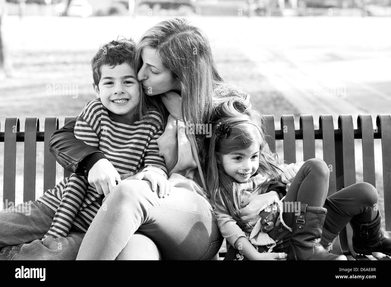 Mutter mit Tochter und Sohn auf Parkbank Stockfoto
