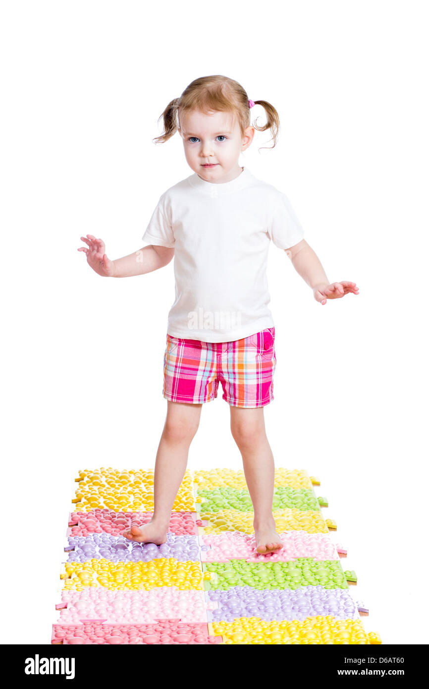kleines Mädchen massieren ihre Füße auf Teppich Stockfoto