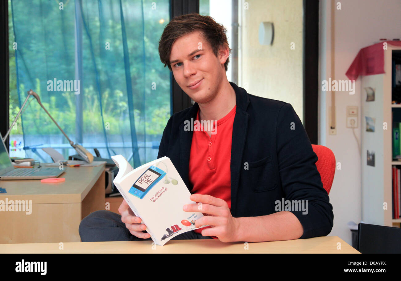 Junger Autor Alexander Karl hält sein erste Buch "Real Me" in Gomaringen, Deutschland, 17. Juli 2012. Es ist jeder Autor Traum, ein Buch auf der Bestsellerliste. Aber als Schriftsteller ist schwierig. Auch Bestseller-Autoren haben sich teilweise mit anderen Aufträgen zu unterstützen. Foto: Marc Herwig Stockfoto