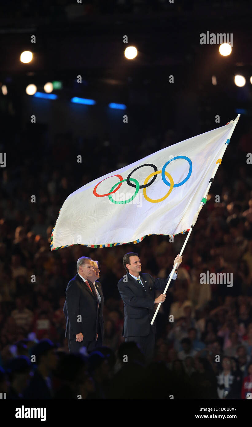 Eduardo Paes (R-L), Bürgermeister von Rio de Janeiro, winkt die Olympische Flagge neben IOC-Präsident Jacques Rogge und Boris Johnson, Bürgermeister von London bei der Abschlussfeier der London 2012 Olympische Spiele im Olympiastadion, London, Großbritannien, 12. August 2012. Foto: Christian Charisius Dpa +++(c) Dpa - Bildfunk +++ Stockfoto