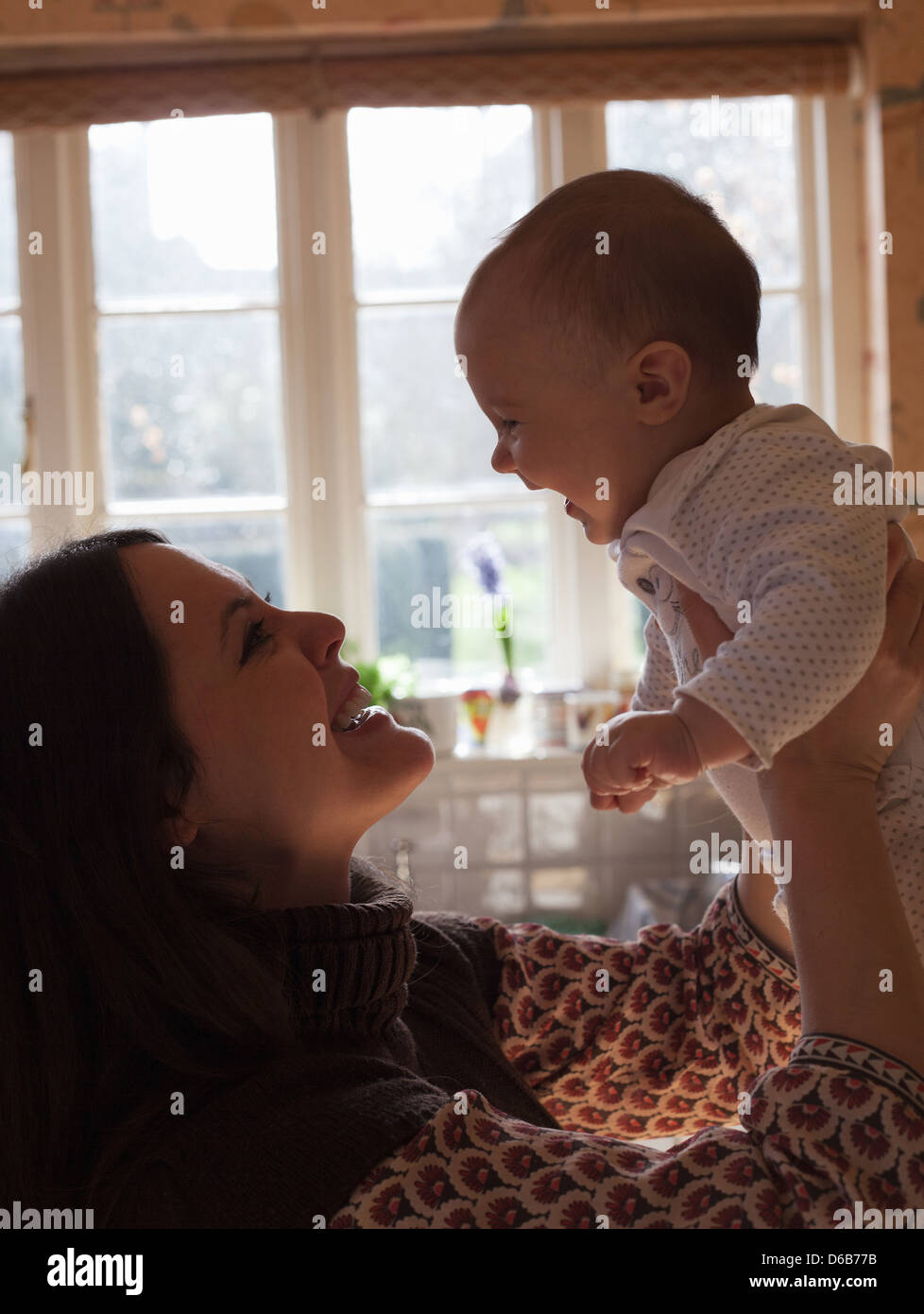 Mutter Babymädchen im Haus halten Stockfoto