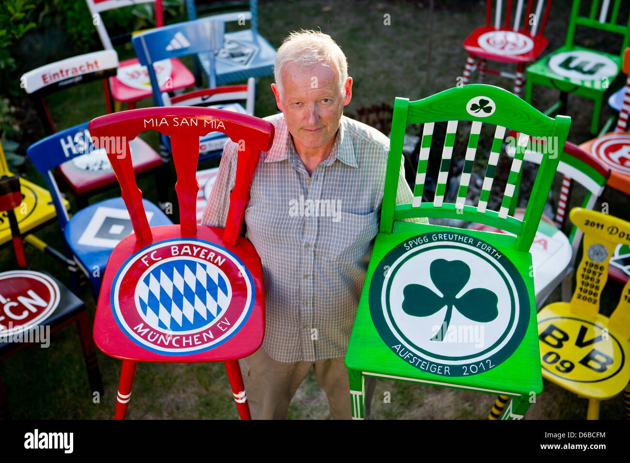 Ehemaliger Beamter der Bvarian Football Association, die Manfred Roedig mit Stühlen stellt gemalt mit den Logos der deutschen Bundesliga Fußballvereine, abgebildet in Schwabach, Deutschland, 23. August 2012. Die Rentner dekoriert die Stühle in Erwartung an den Start der neuen Bundesliga-Saison. Foto: Daniel Karmann Stockfoto