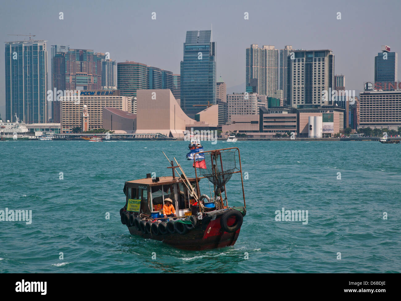 China, Hong Kong, motorisierte Sampan auf Victoria Harbour vor der Kulisse der Skyline von Tsim Sha Tsui Stockfoto